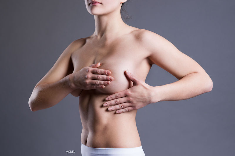 Woman performing a breast self-exam
