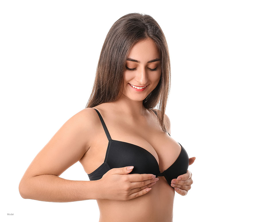 Women in black bra lifting her breasts.