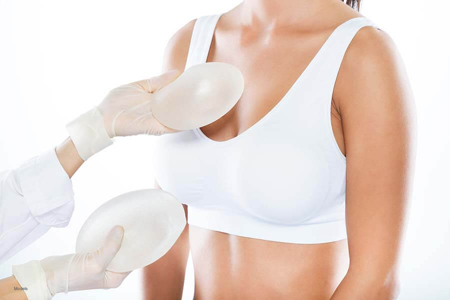 A doctor shows a woman different breast implant options.
