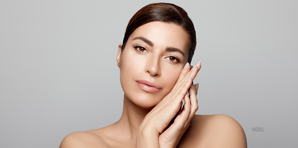 young woman with both hands under her chin