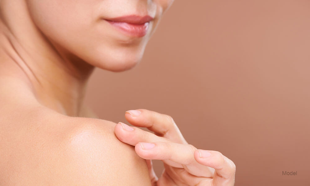  woman touching her shoulder