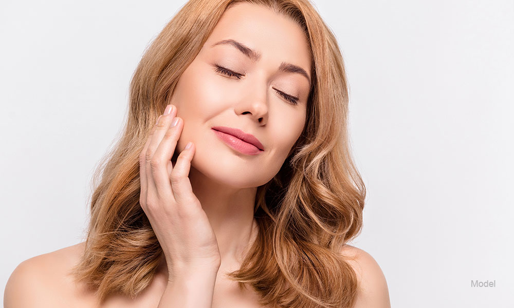 woman touching her face smiling