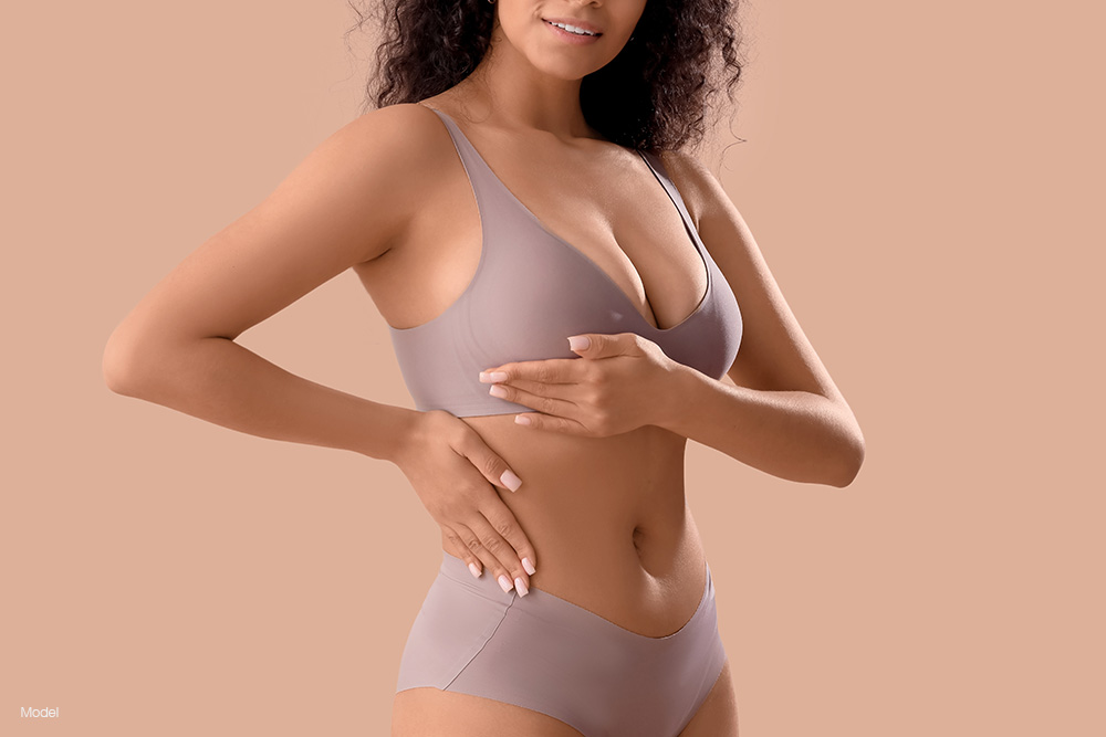 curvy woman in gray underwear holding her breast